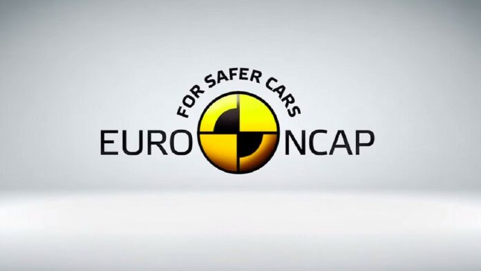 Euro NCAP - na szarym tle centralnie umieszczono logo europejskiej organizacji. Po środku znajduje się żółte koło, podzielone w pionie i poziomie, czarnymi liniami. Lewa górna i prawa dolna ćwiartka częściowo zaczernione. Po lewej czarny napis EURO, po prawej NCAP. Powyżej półkoliście ułożony napis For Safer Cars.