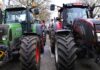 fala rolniczych protestów - podwójny rząd ogromnych maszyn rolniczych blokujących drogę.
