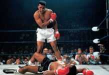 Muhammad Ali - na ringu leży czarnoskóry bokser w czarnych spodenkach, nad nim stoi czarnoskóry zwycięzca w białych spodenkach.