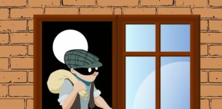 jak zabezpieczyć mieszkanie na majówkę - kreskówkowy złodziej przechodzi przez okno