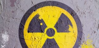wzbogacony uran - na betonowej ścianie, namalowany symbol promieniowania. W żółtym kole z czarną obwódką, umieszczony jest trzy-ramienny wiatrak w kolorze czarnym. Jedno z jego ramion jest skierowane pionowo w dół.
