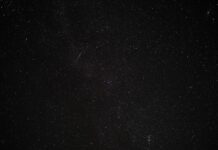 nocne widowisko na niebie - spadający meteor na rozgwieżdżonym niebie