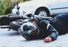 sezon motocyklowy - martwa motocyklistka w czarnym kombinezonie i kasku, leży na drodze obok swojego motocykla. W tle biały samochód osobowy.