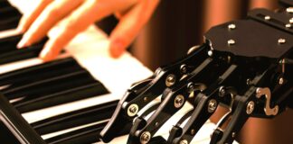 Australia stawia granice AI w muzyce a na zdjęciu pianino iręce pianisty i robota