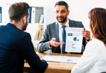 Nowe oszustwo na analityka finansowego zbiera żniwo – poradnik jak rozpoznać zagrożenie oszustwo na analityka finansowego - na zdjęciu analityk przystole z arkuszem danych w ręku i potencjalne ofiary
