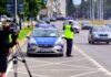 masowe kontrole drogowe na zdjęciu policjant mierzy prędkość radarem