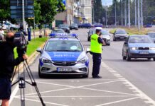 masowe kontrole drogowe na zdjęciu policjant mierzy prędkość radarem